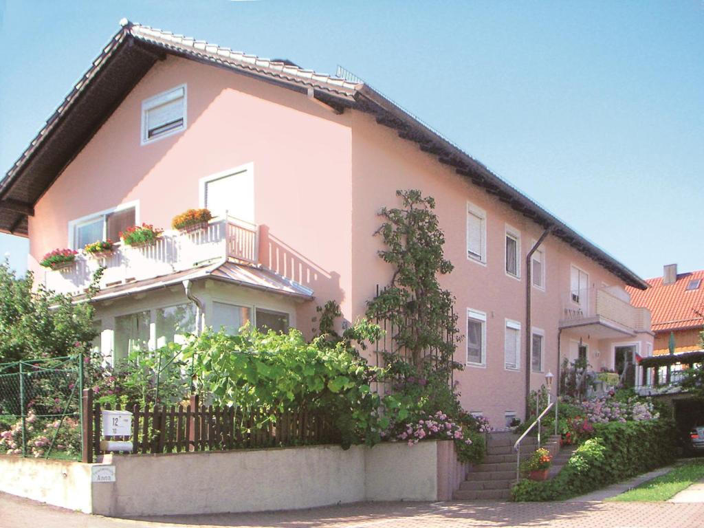 uma casa cor-de-rosa com uma vedação à frente. em Ferienwohnungen Anna em Bad Birnbach