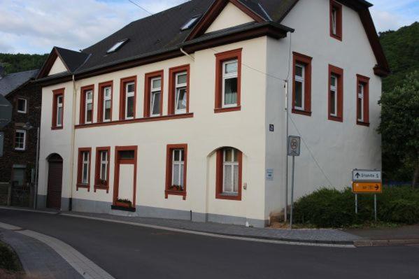 a large white building with red windows on a street at Ferienwohnung Meuser in Traben-Trarbach