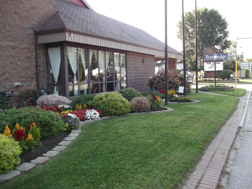 a building with a bunch of flowers in front of it at Travelodge by Wyndham North Bay Lakeshore in North Bay