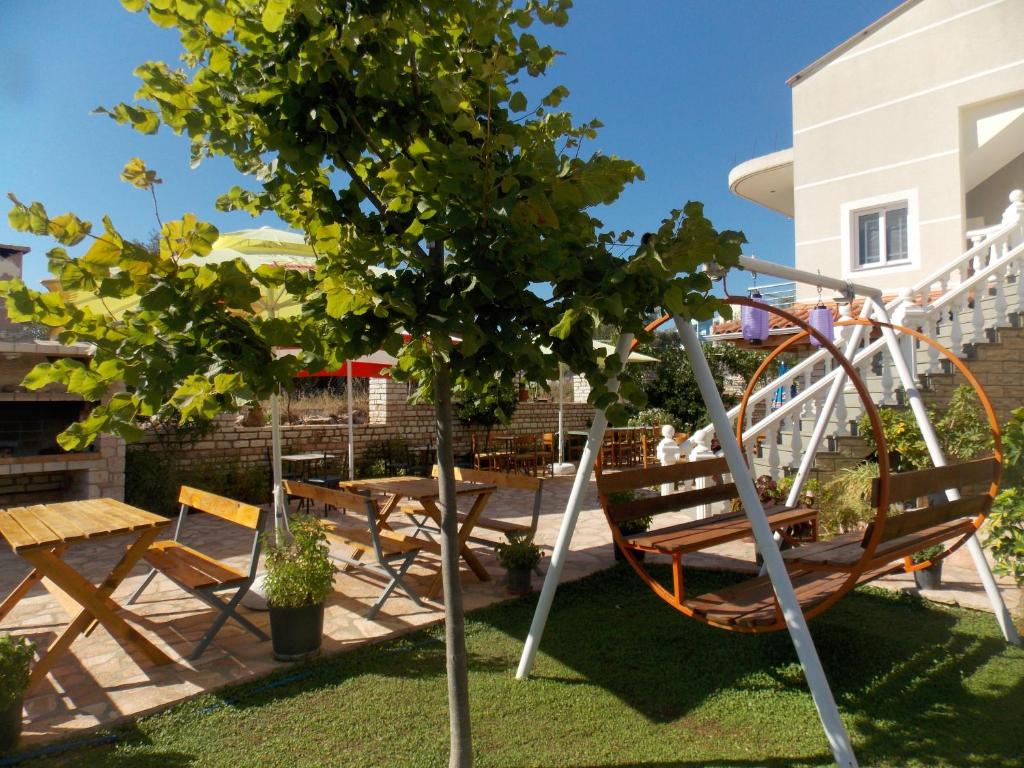 a playground with a tree and a swing at Hotel Chris in Ksamil