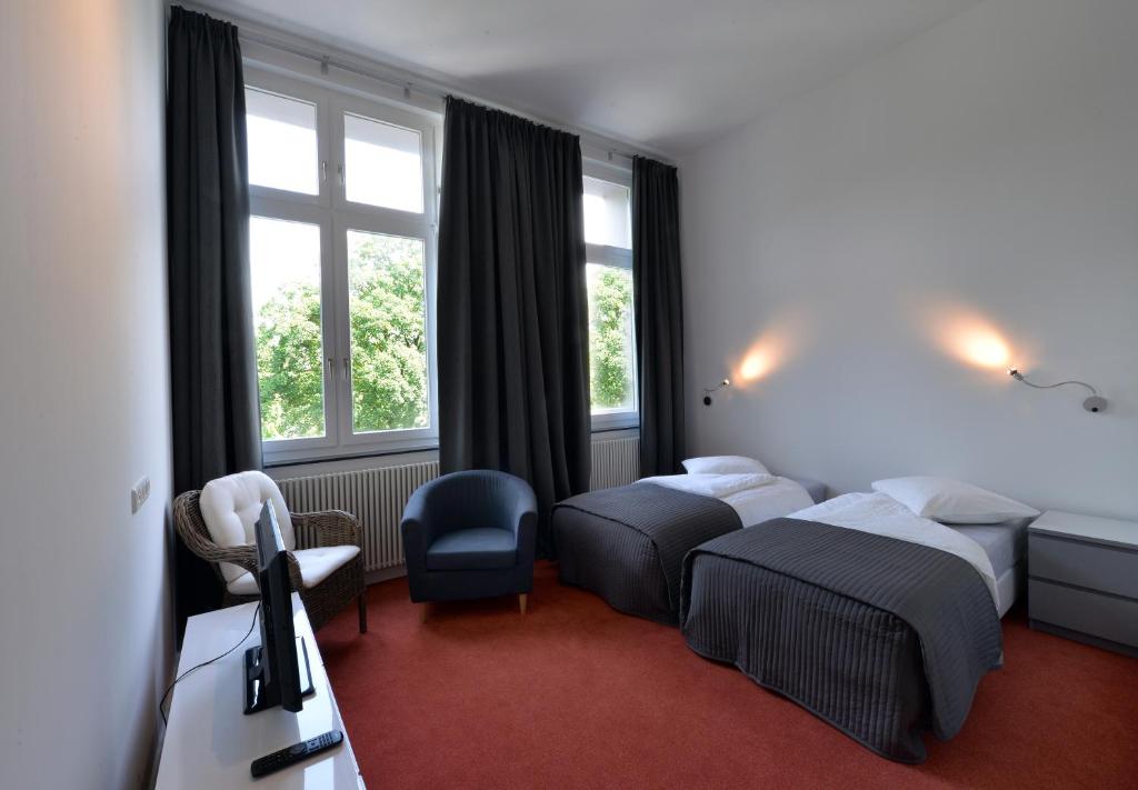 um quarto de hotel com duas camas e uma janela em Park Apartaments em Aachen