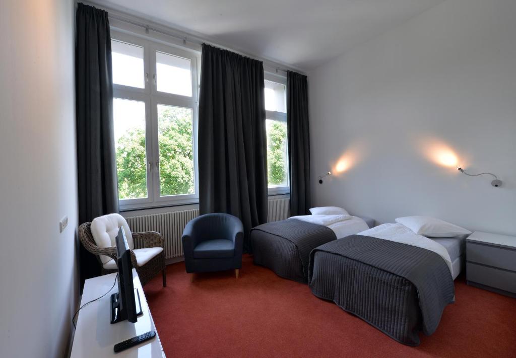 ein Hotelzimmer mit 2 Betten und einem Fenster in der Unterkunft Park Apartaments in Aachen