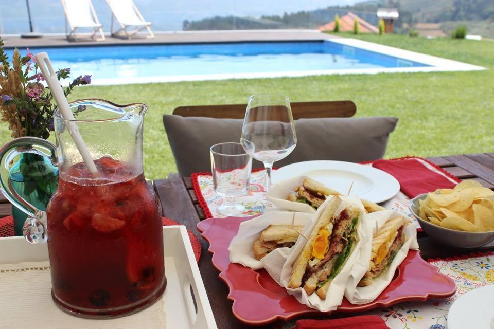 una mesa con un sándwich y patatas fritas y una bebida en Casas da Li, en Arcos de Valdevez