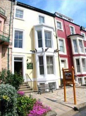 a white building with a bench in front of it at Pinewood House in Whitby