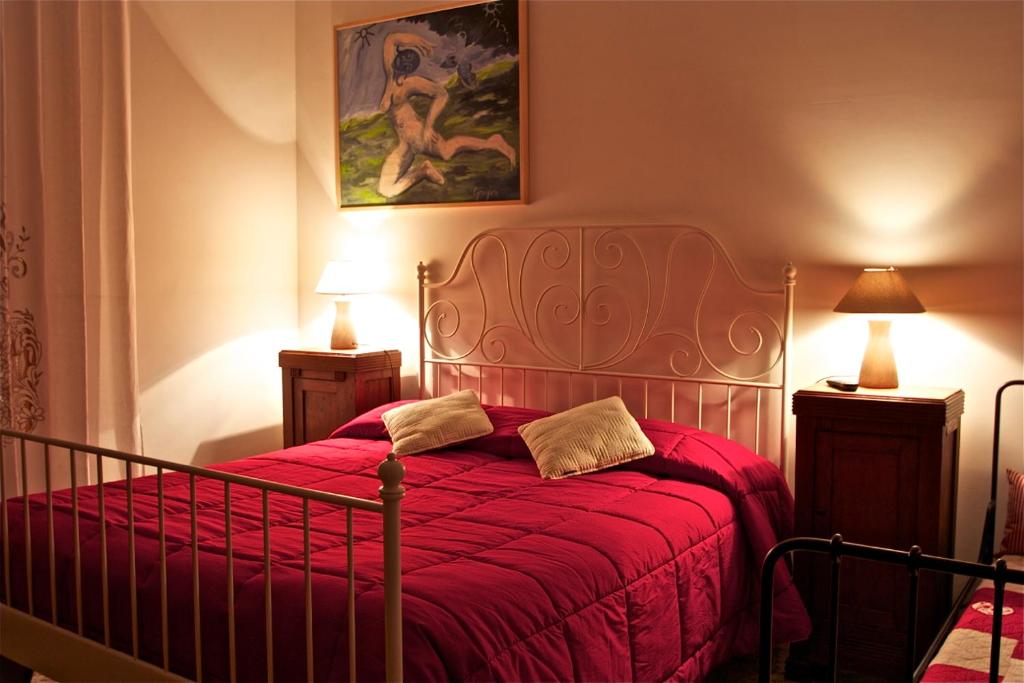 sypialnia z łóżkiem z czerwoną kołdrą w obiekcie Affittacamere La Casa Di Elide w Arezzo