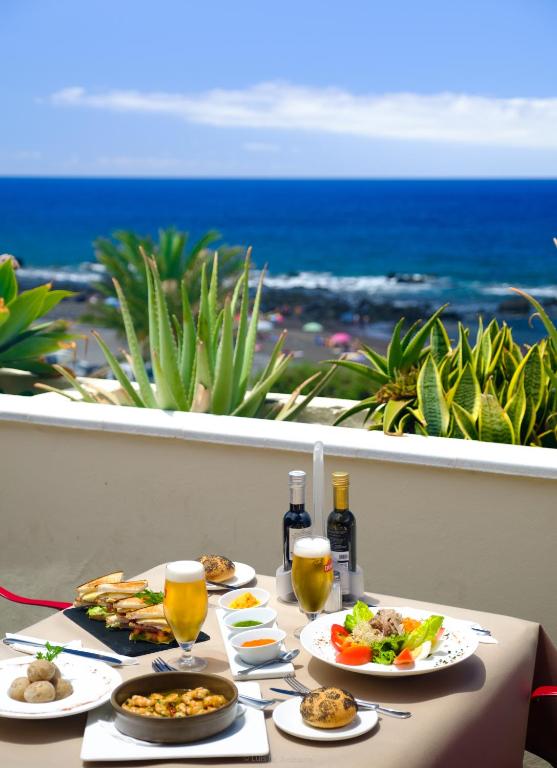 a table with plates of food and glasses of wine at Hotel Gran Rey in Valle Gran Rey