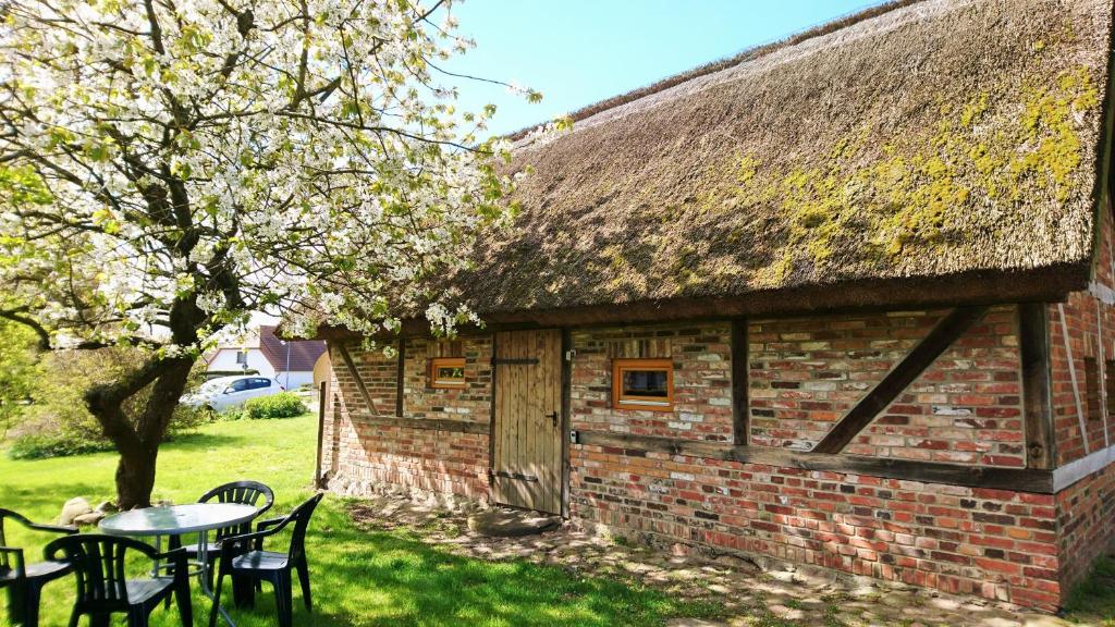 un edificio con techo de hierba, mesa y sillas en Ferienhaus am Radwanderweg, en Klausdorf, Mecklenburg-Vorpommern