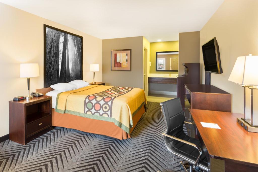 a hotel room with a bed and a desk at Super 8 by Wyndham Fortuna in Fortuna