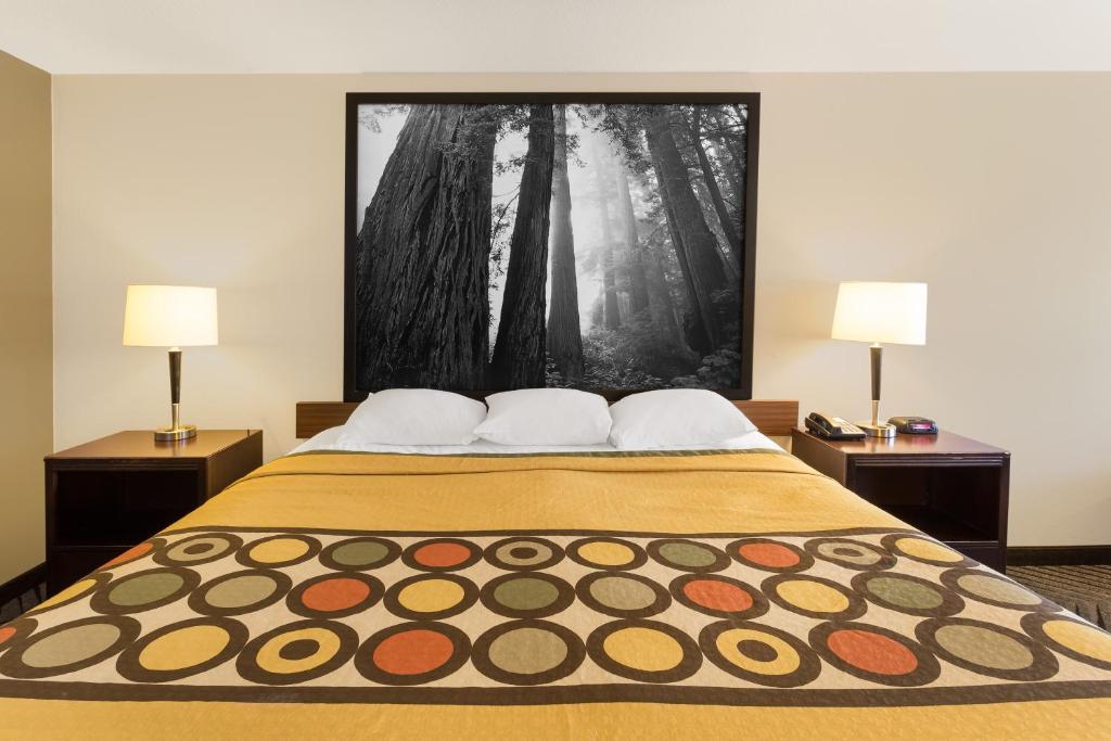a bedroom with a large bed with two lamps at Super 8 by Wyndham Fortuna in Fortuna