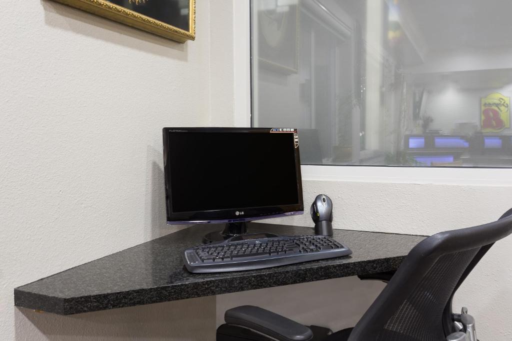 a computer monitor and a keyboard on a desk at Super 8 by Wyndham Fortuna in Fortuna