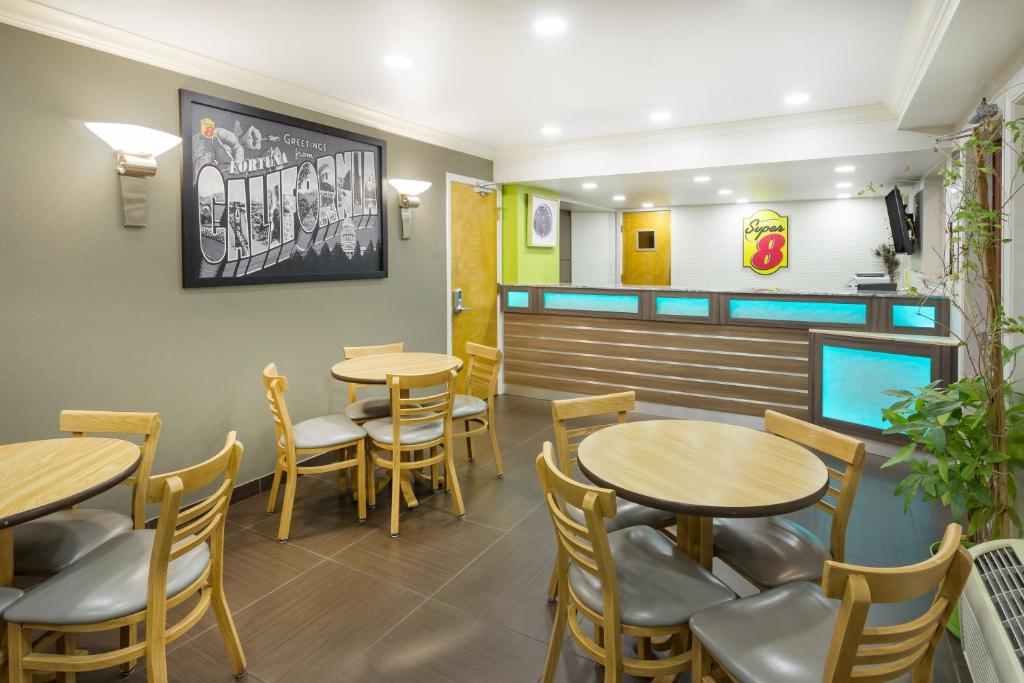a dining room with tables and chairs in a restaurant at Super 8 by Wyndham Fortuna in Fortuna