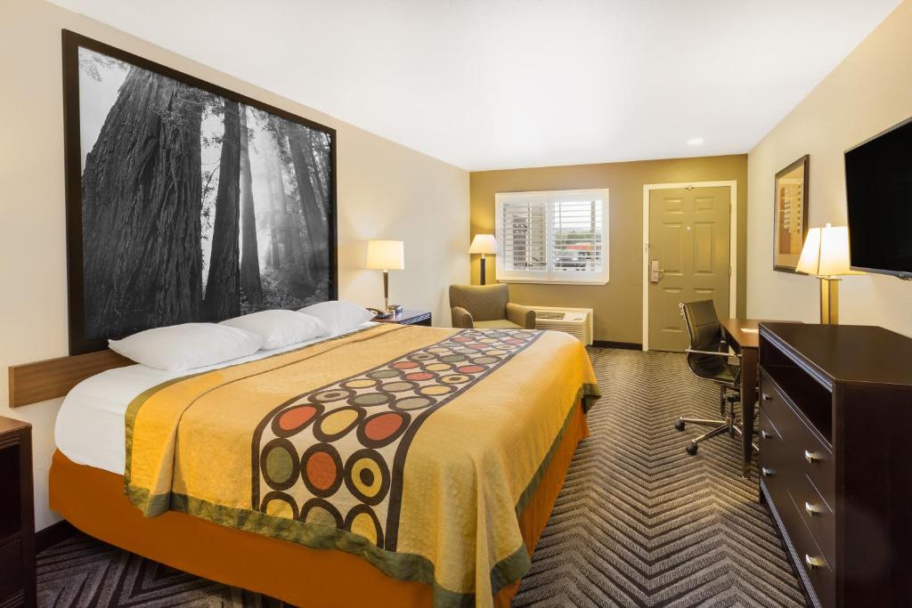 a hotel room with a large bed and a desk at Super 8 by Wyndham Fortuna in Fortuna