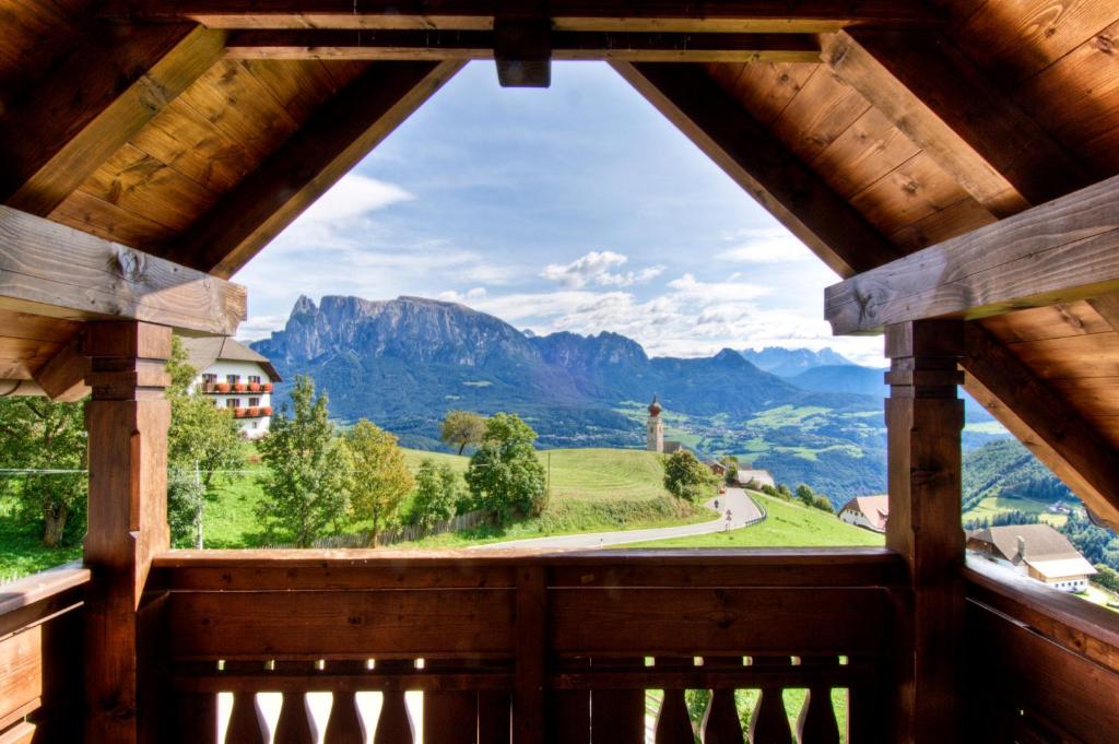 a window in a wooden building with a view of mountains at Residenz am Kaiserweg in Longostagno