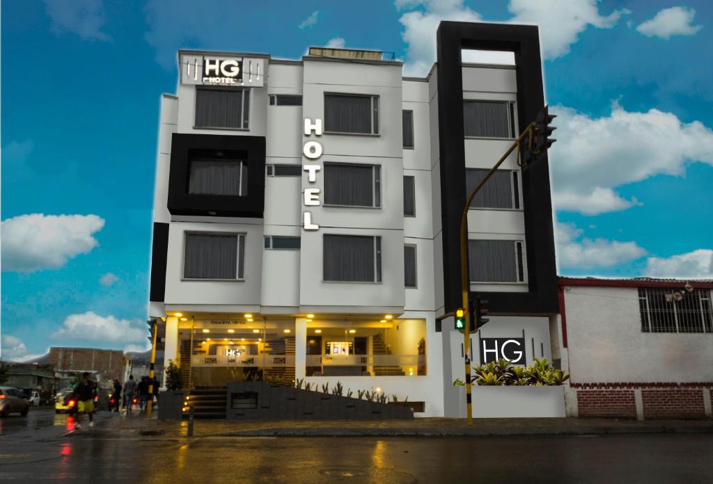 a white building with a sign on it at HYG Hotel in Pasto