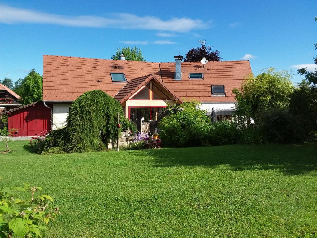 una casa con un granero rojo en un patio en Le grivé, en Chèvremont