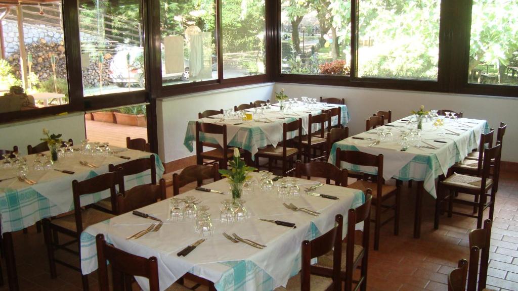 pokój ze stołami i krzesłami w pokoju z oknami w obiekcie Agriturismo Costiera Amalfitana w mieście Tramonti