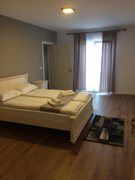 a bedroom with a large bed and a window at Provincial in Vişeu de Jos