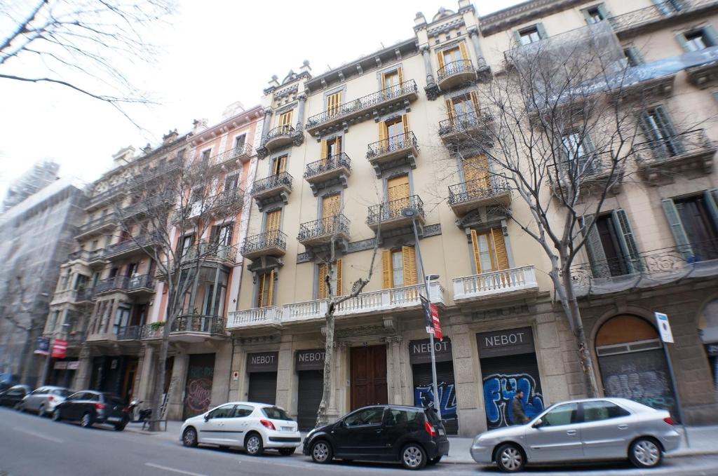 バルセロナにあるペンション カサ デ バルサの大きな建物の前に駐車した車両2台