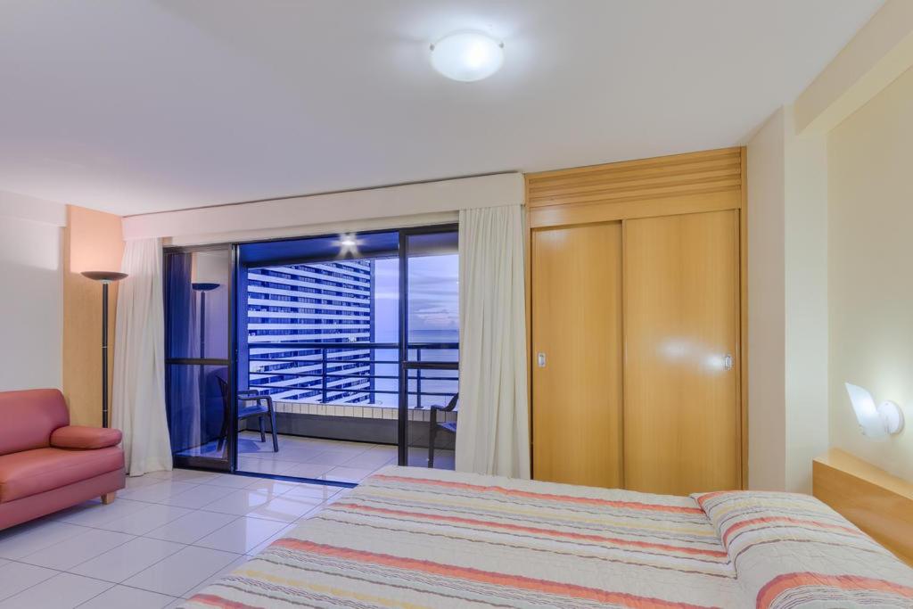 1 dormitorio con cama y vistas a un balcón en Praia Mansa LRM., en Fortaleza