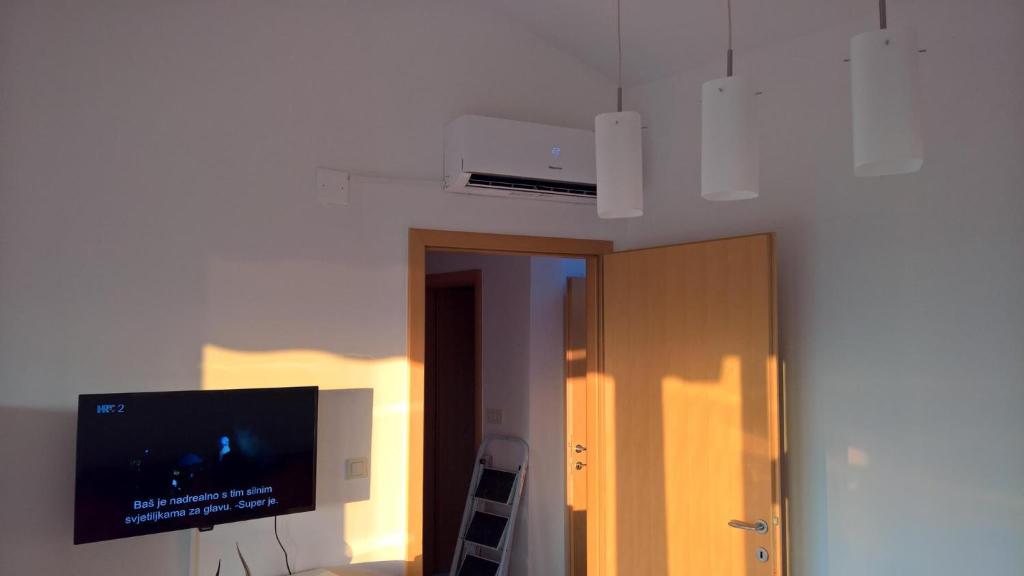 Cette chambre dispose d'une télévision à écran plat au plafond. dans l'établissement Apartment Poleti, à Malinska