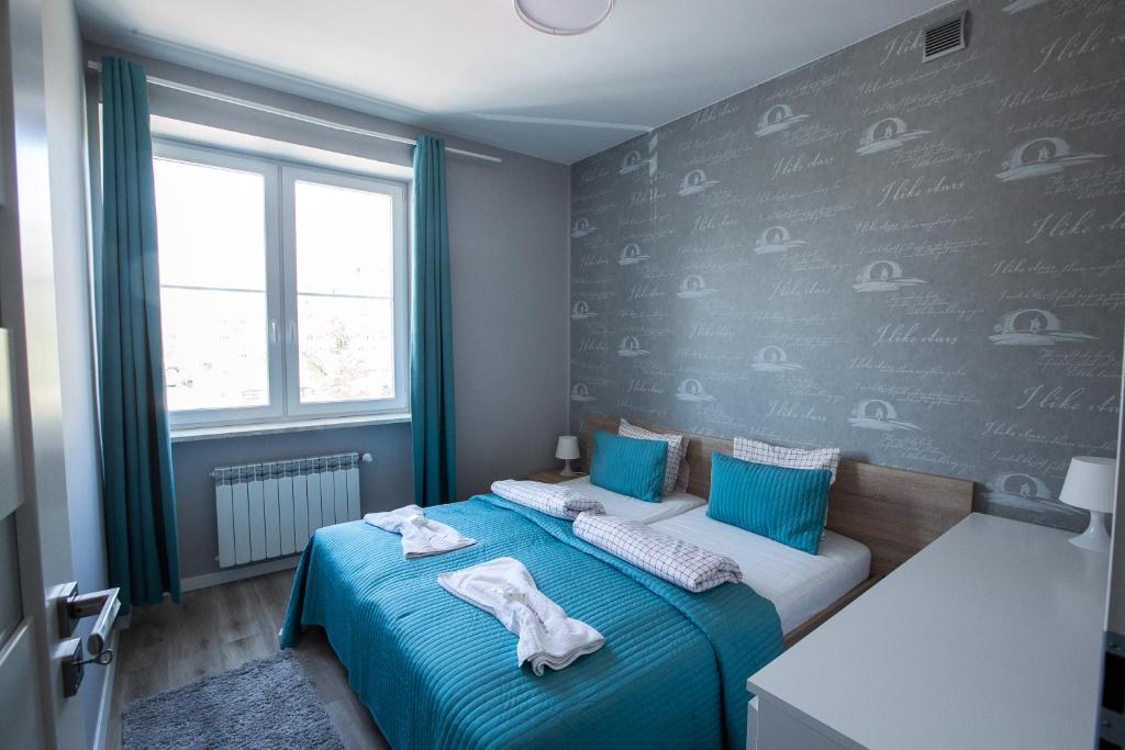 ワルシャワにあるCandy Studio Bezobsługowyのベッドルーム1室(青いシーツと窓付)