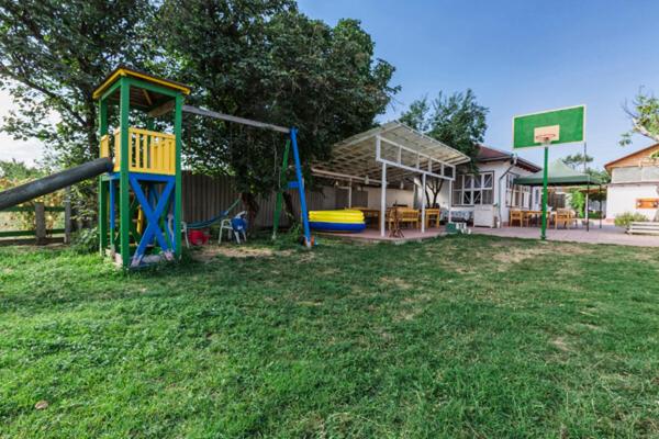 a park with a playground with a slide in the grass at Village Rooms Guesthouse in İvanovka