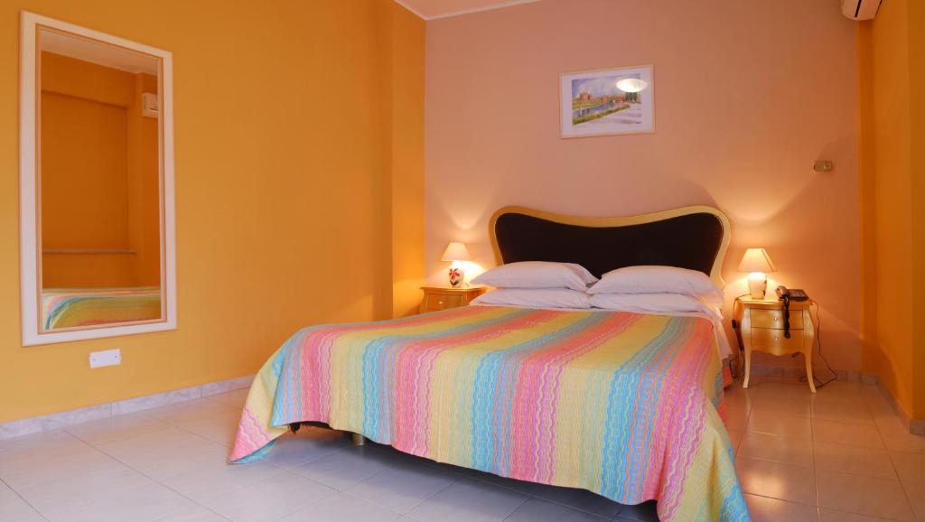a bedroom with a bed with a colorful bedspread at Hotel Michelangelo in Teramo