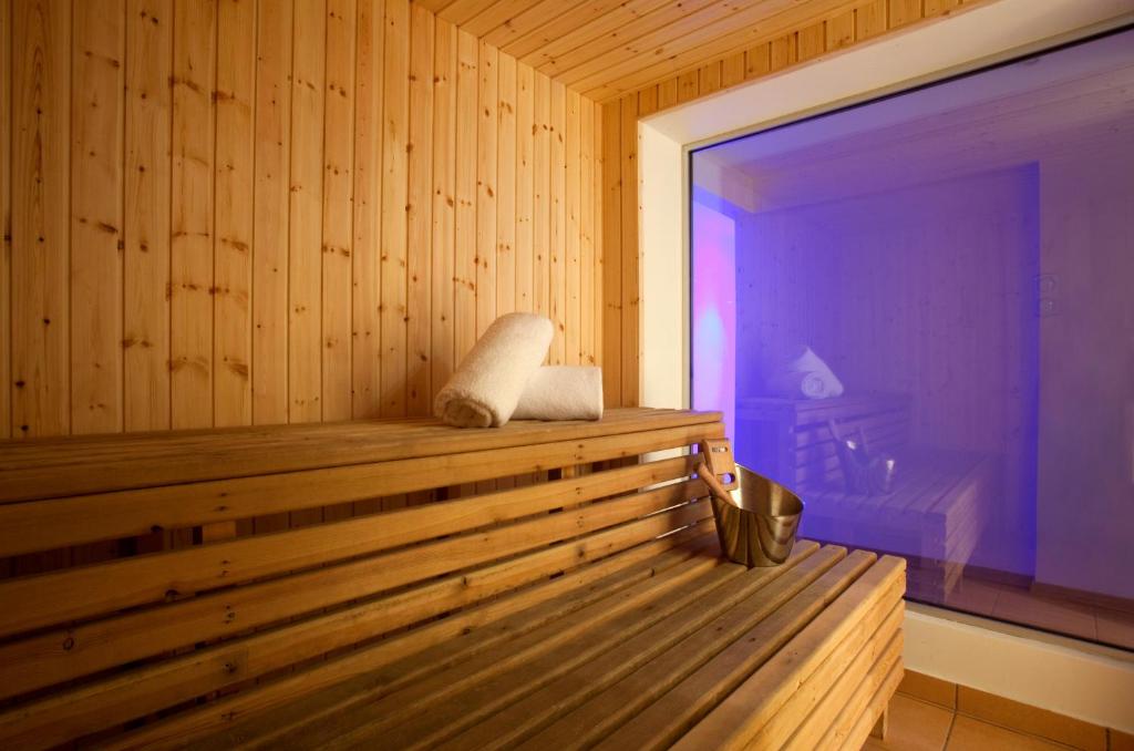 a wooden sauna with a bench in a room at Sandy Beach Hotel & Spa - ex Sentido in Larnaca
