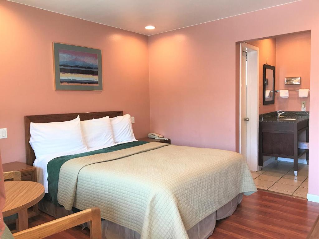 a hotel room with a bed and a sink at Bestway Inn in Grants Pass