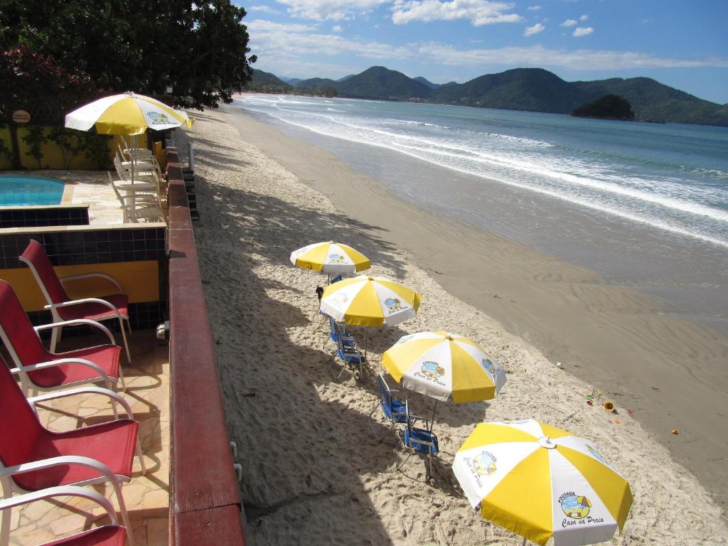 
a row of beach chairs sitting on top of a beach at Pousada Casa na Praia in Ubatuba
