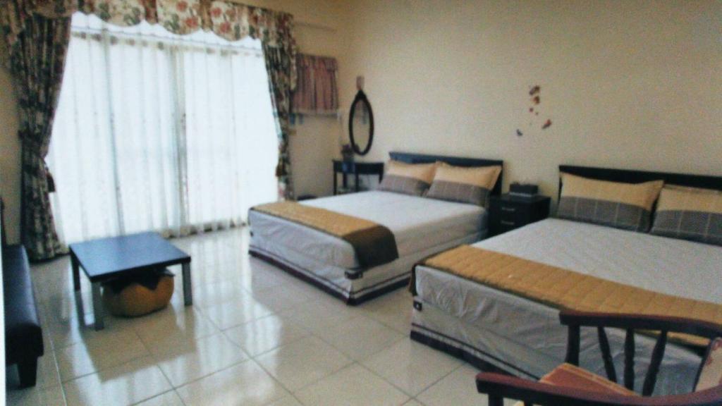 Habitación de hotel con 2 camas y mesa en Chulu Wenxin Xiao Zhan Homestay, en Chulu