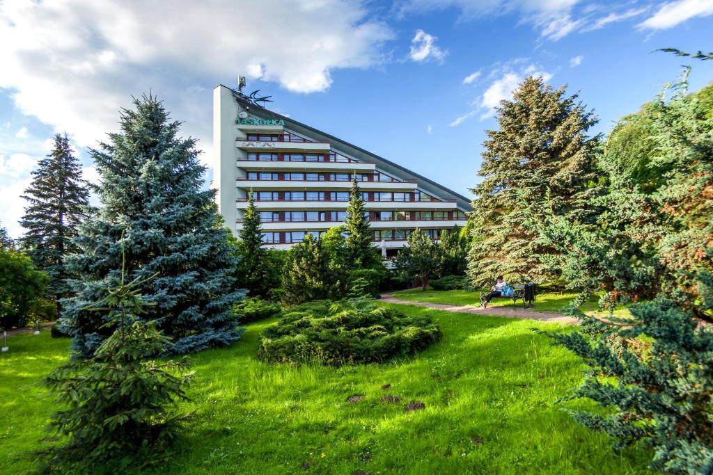 ein großes Gebäude mit Bäumen davor in der Unterkunft Hotel Jaskółka in Ustroń