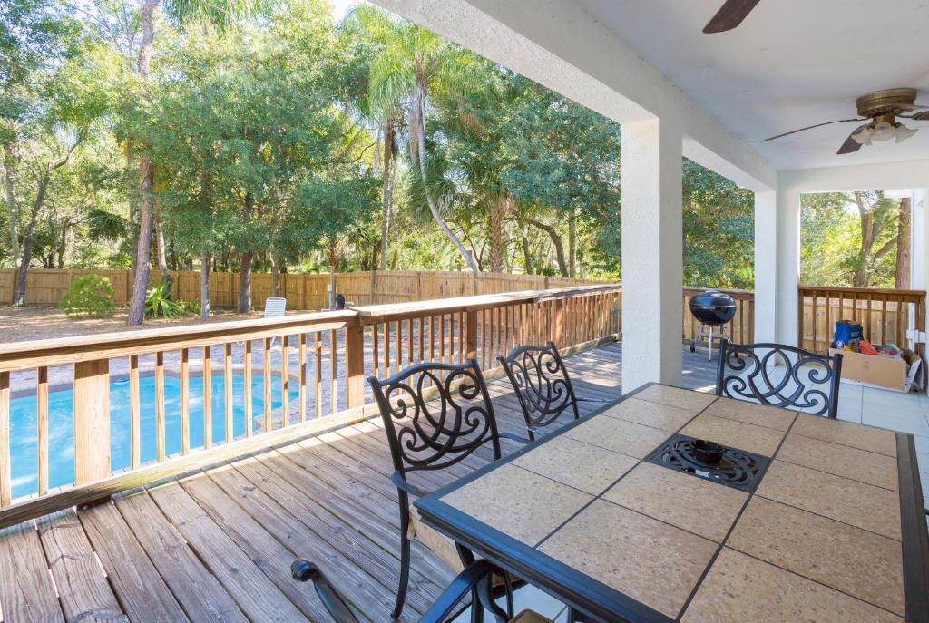 porche con mesa, sillas y piscina en Poolhouse, en Tampa