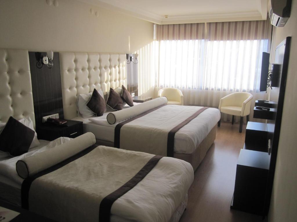a hotel room with two beds and a couch at Alican 1 Hotel in Izmir