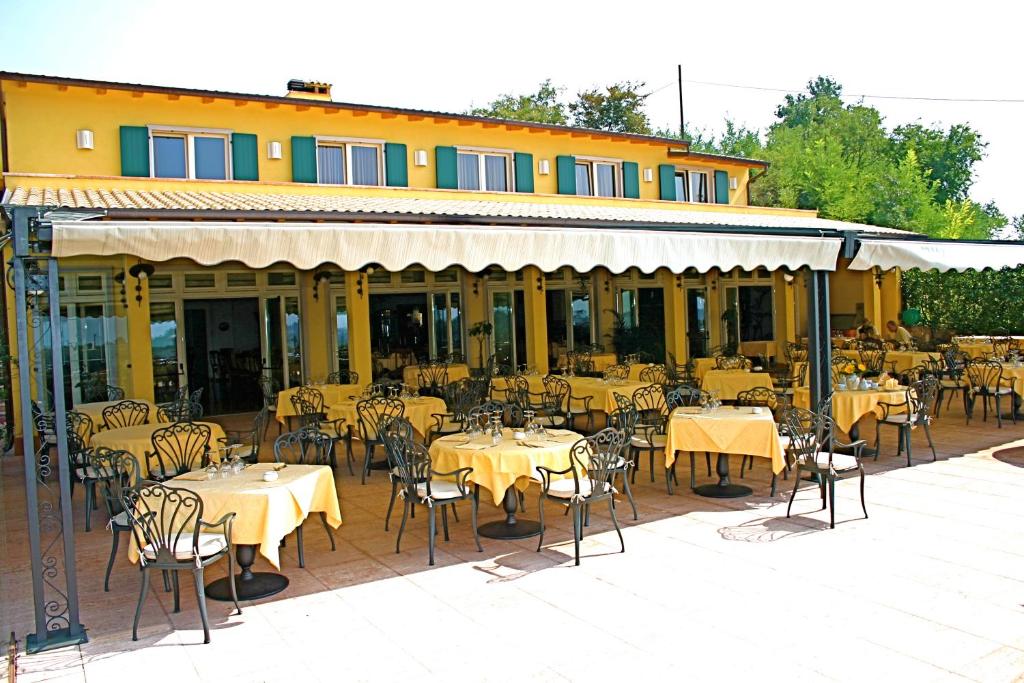 a restaurant with tables and chairs in front of a building at Hotel La Dolce Vita in Cavaion Veronese