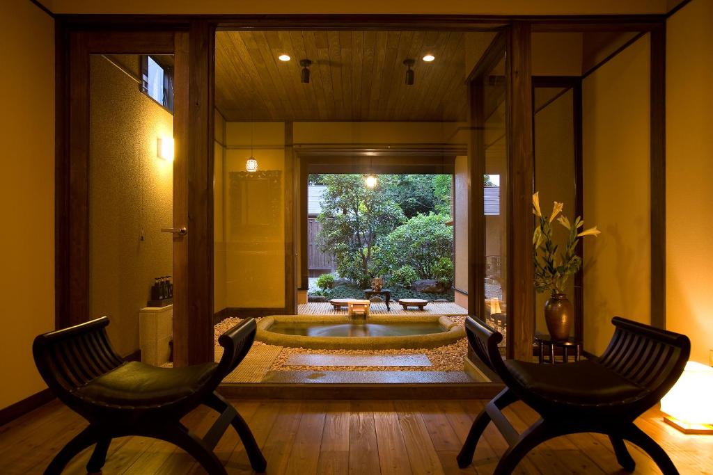 un ampio bagno con vasca e 2 sedie di Bettei Haruki a Beppu