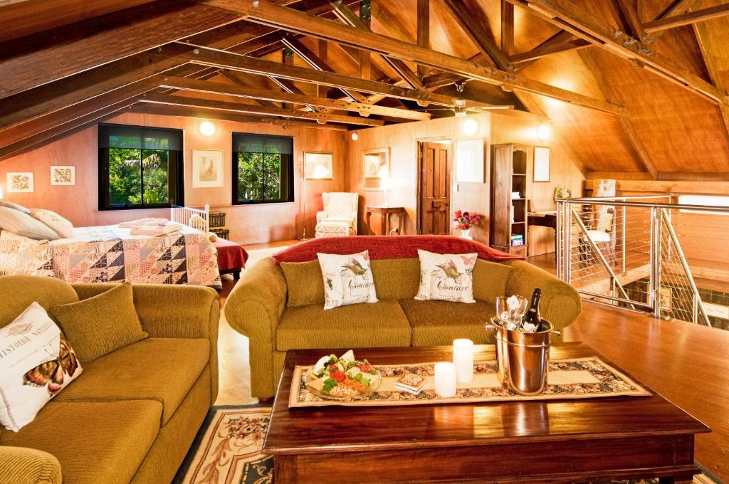 uma sala de estar com um sofá e uma mesa em Possum Lodge At Cloudhill Estate em Mount Tamborine