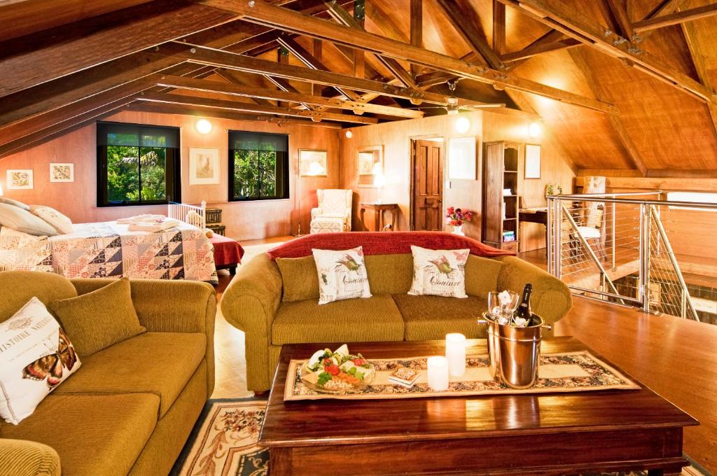 un soggiorno con un divano e un tavolo di Possum Lodge At Cloudhill Estate a Mount Tamborine