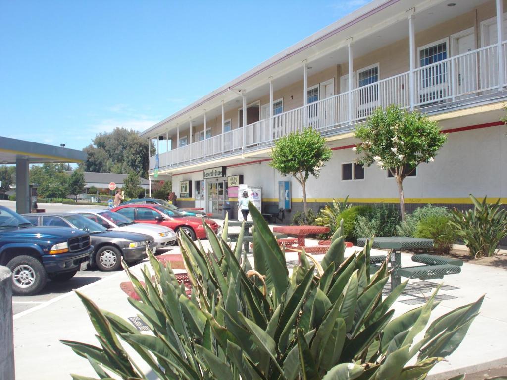 un estacionamiento con autos estacionados frente a un edificio en Garlic Farm Inn, en Gilroy