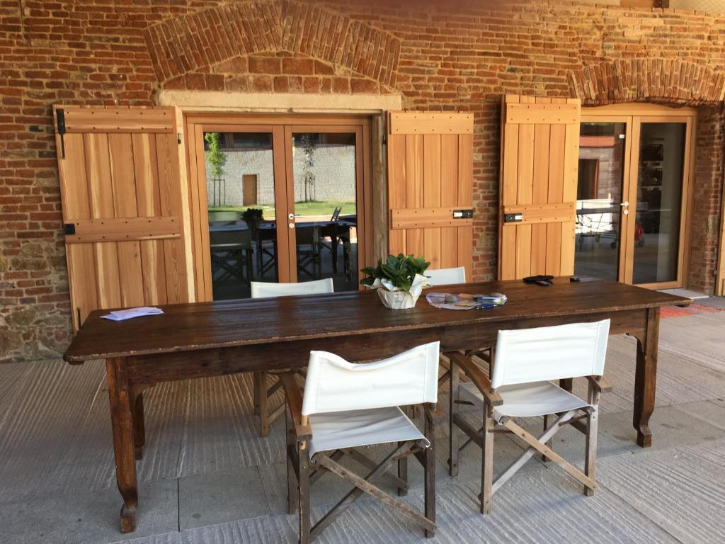 a wooden table with white chairs around it at Agriturismo Corte Bertesina in Vicenza