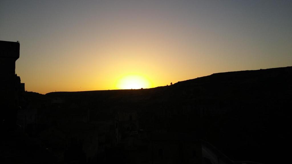 un tramonto su una collina con il tramonto di Tutte le Albe nei Sassi a Matera