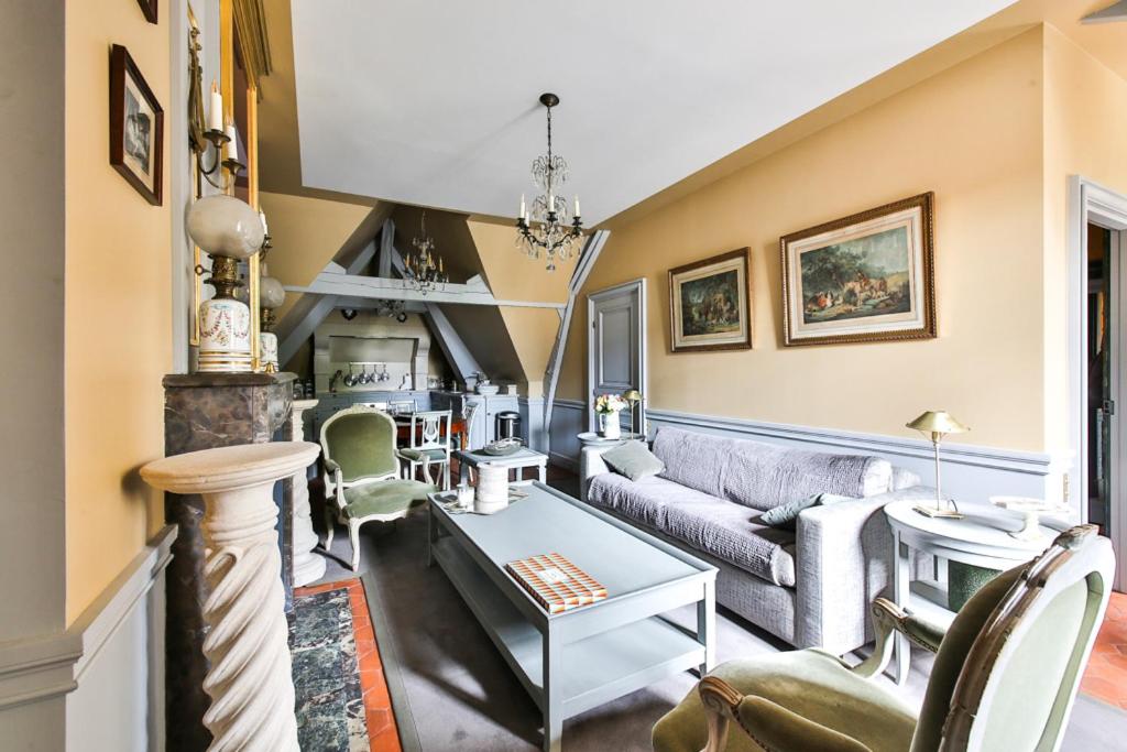 a living room with a couch and a table at Parc Royal Appartements in Paris