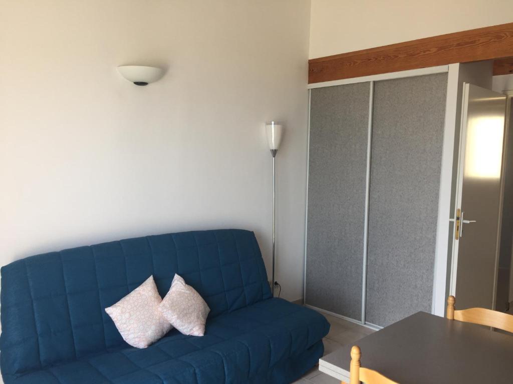 a blue couch in a living room with a table at Résidence Fior di Rena in Saint-Florent