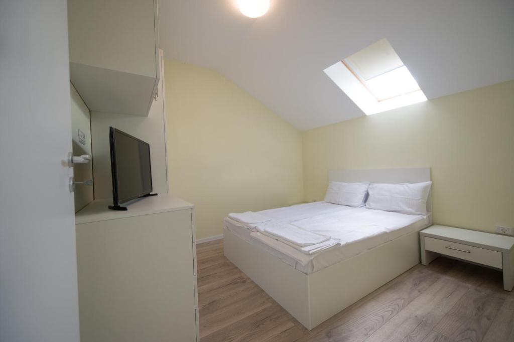 ティミショアラにあるGaga Residence 14の白い小さなベッドルーム(ベッド1台、天窓付)