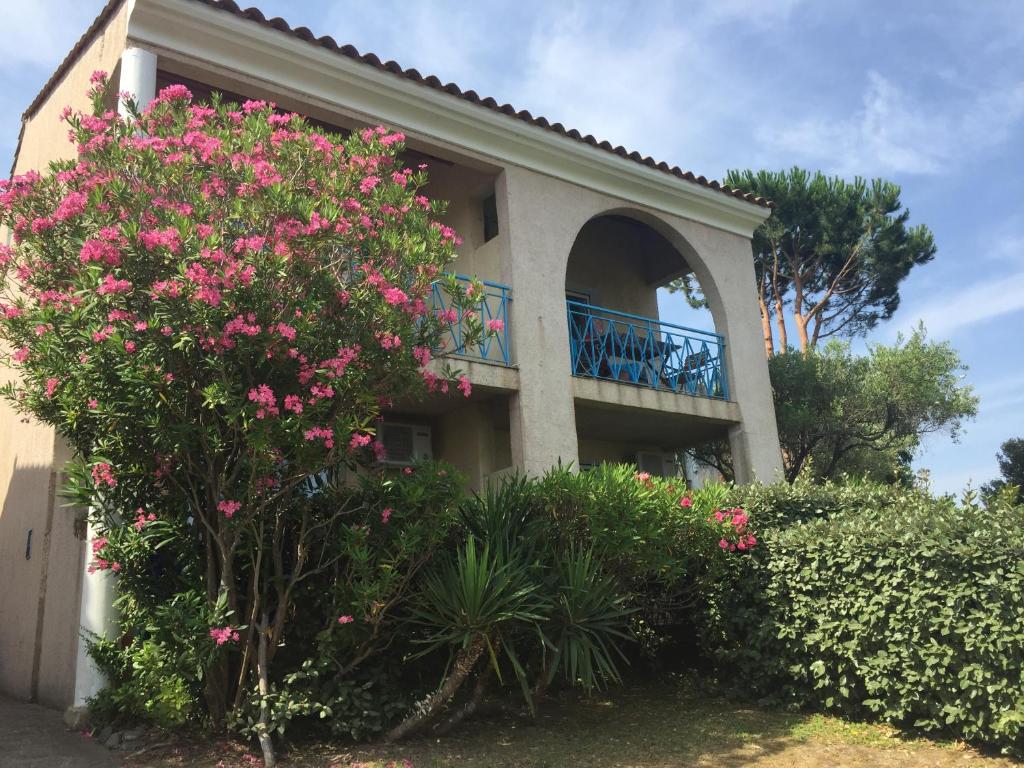 a house with pink flowers and a balcony at Résidence Fior di Rena in Saint-Florent
