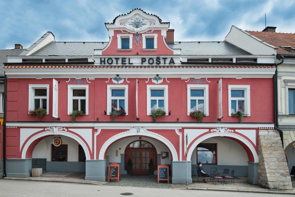 un bâtiment rouge avec un pisa d'hôtel dans l'établissement Hotel Pošta, à Sobotka