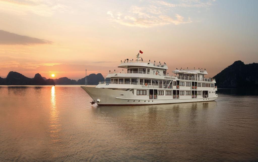 a cruise ship in the water at sunset at Halong Athena Cruise in Ha Long