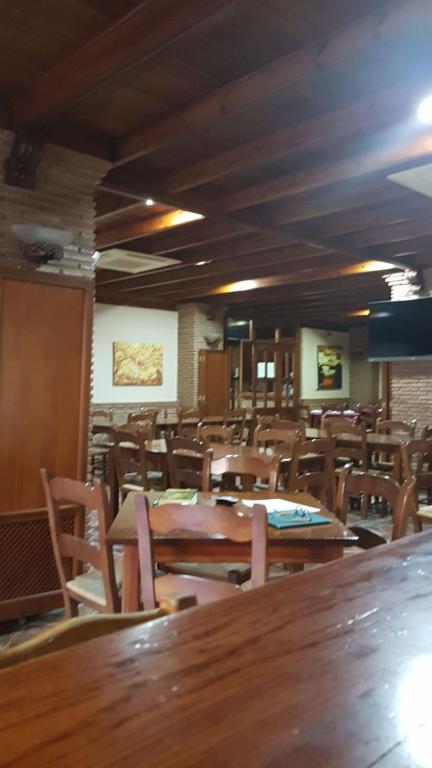 pusta restauracja z drewnianymi stołami i krzesłami w obiekcie Hospedería Los Cahorros w mieście Monachil