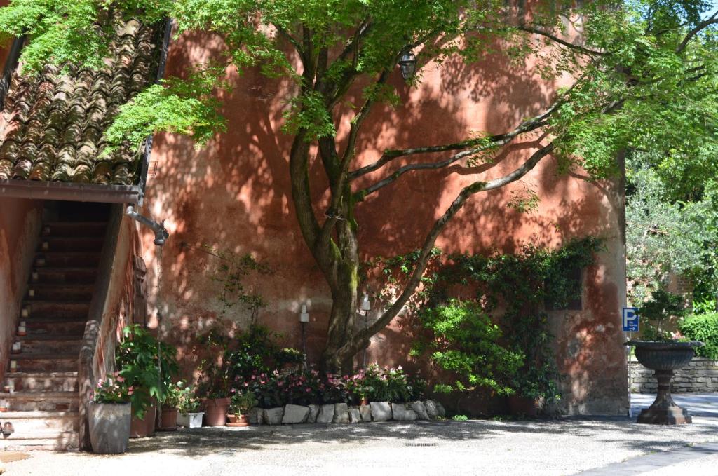 un árbol en el lateral de un edificio con flores en Villa Valentina, en Tradate
