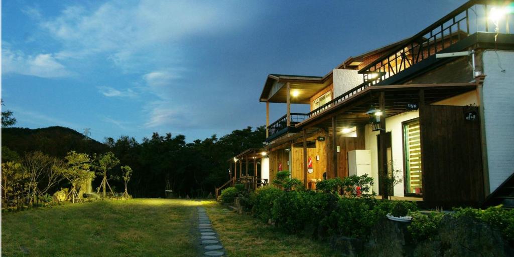 a house with lights on the side of it at Gotjawal Geomunoreum Pension in Jeju